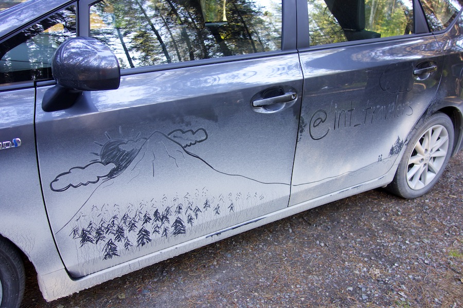 prius car exterior with mountain scene drawn in the dust