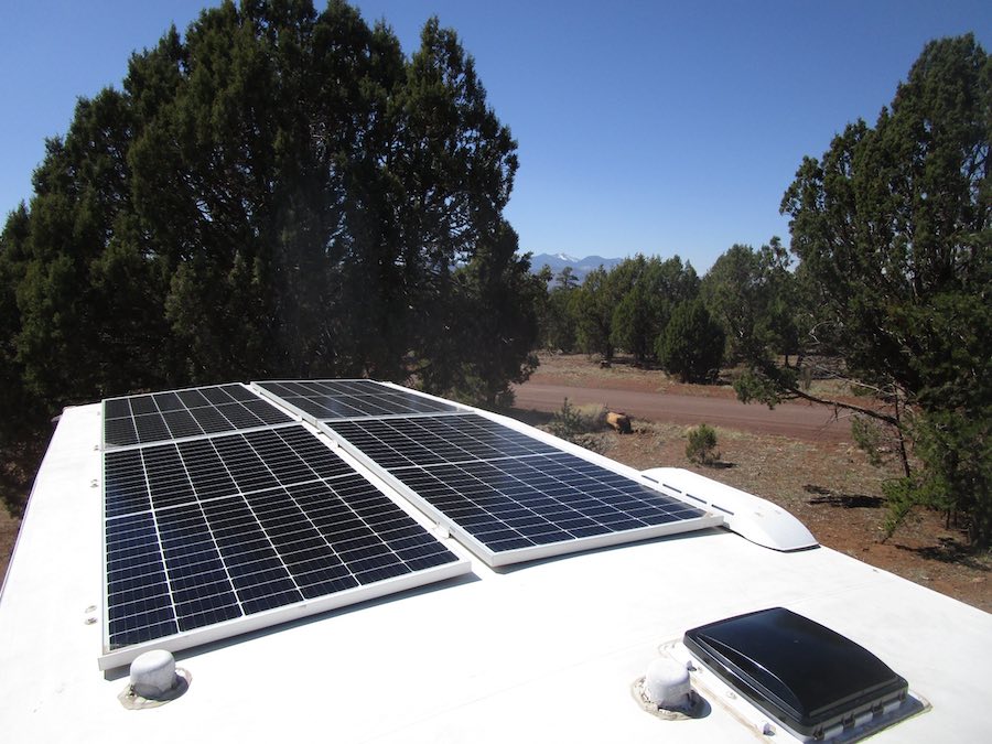 solar panels on travel trailer with trees in background