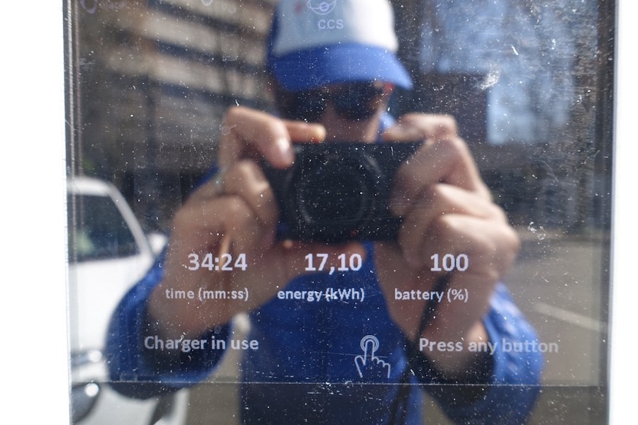 J taking a photo of EV charging stats at charging station